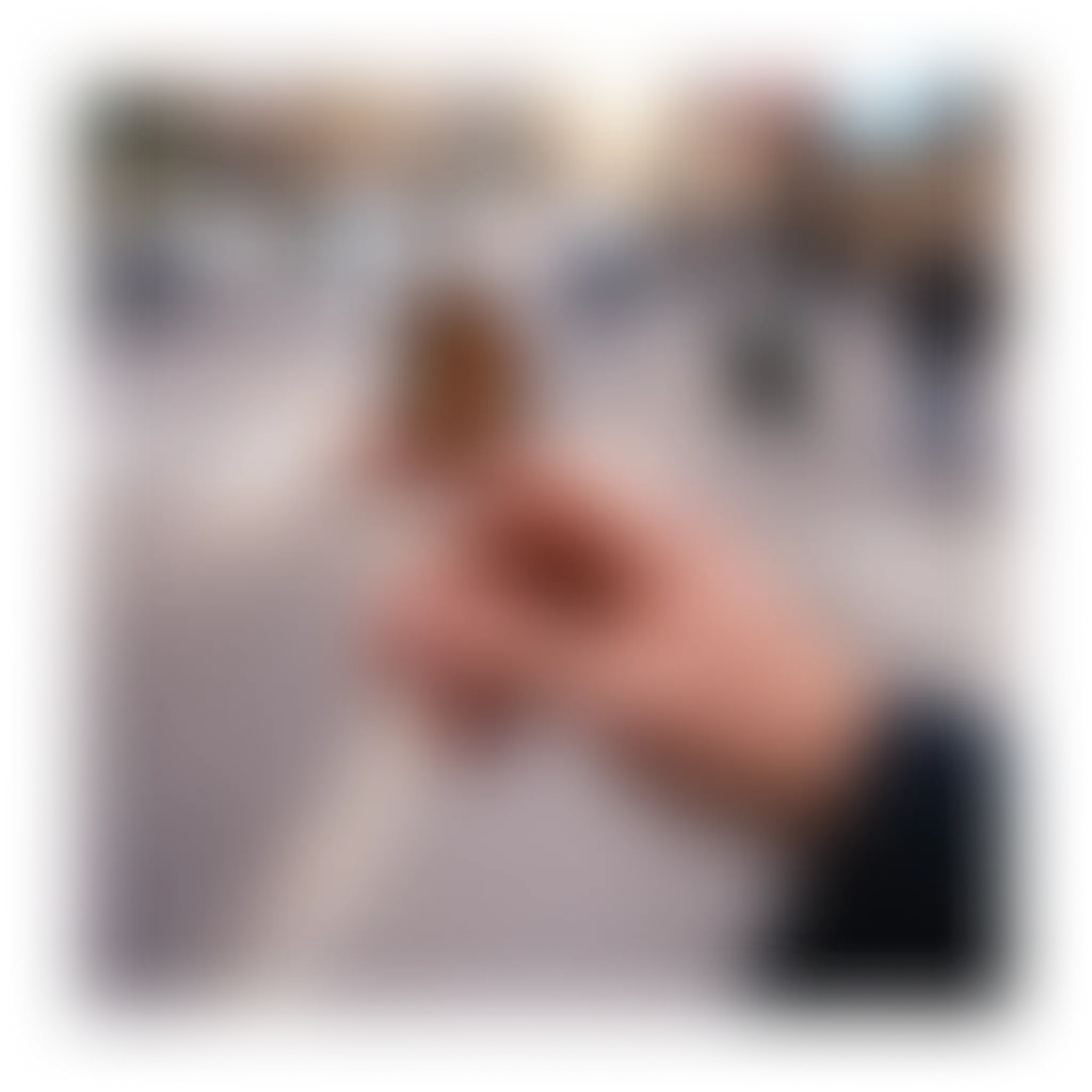 Blurred close-up of a person's hand with fingers interlocking, soft background.