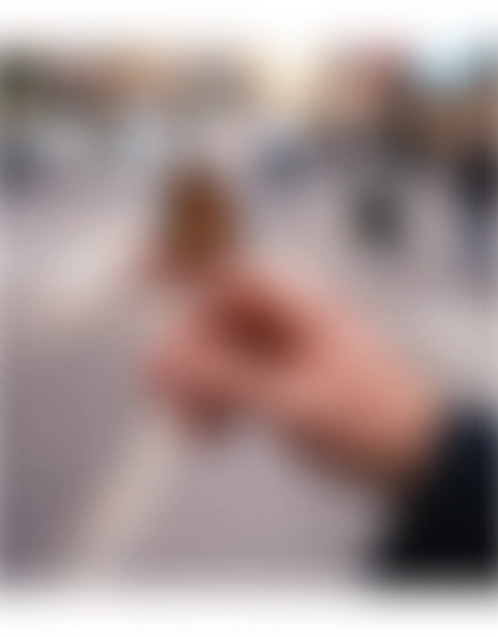 Blurred close-up of a person's hand with fingers interlocking, soft background.